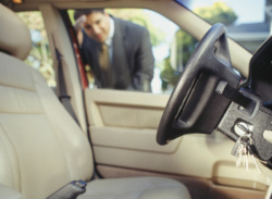 businessman looking in locked car window